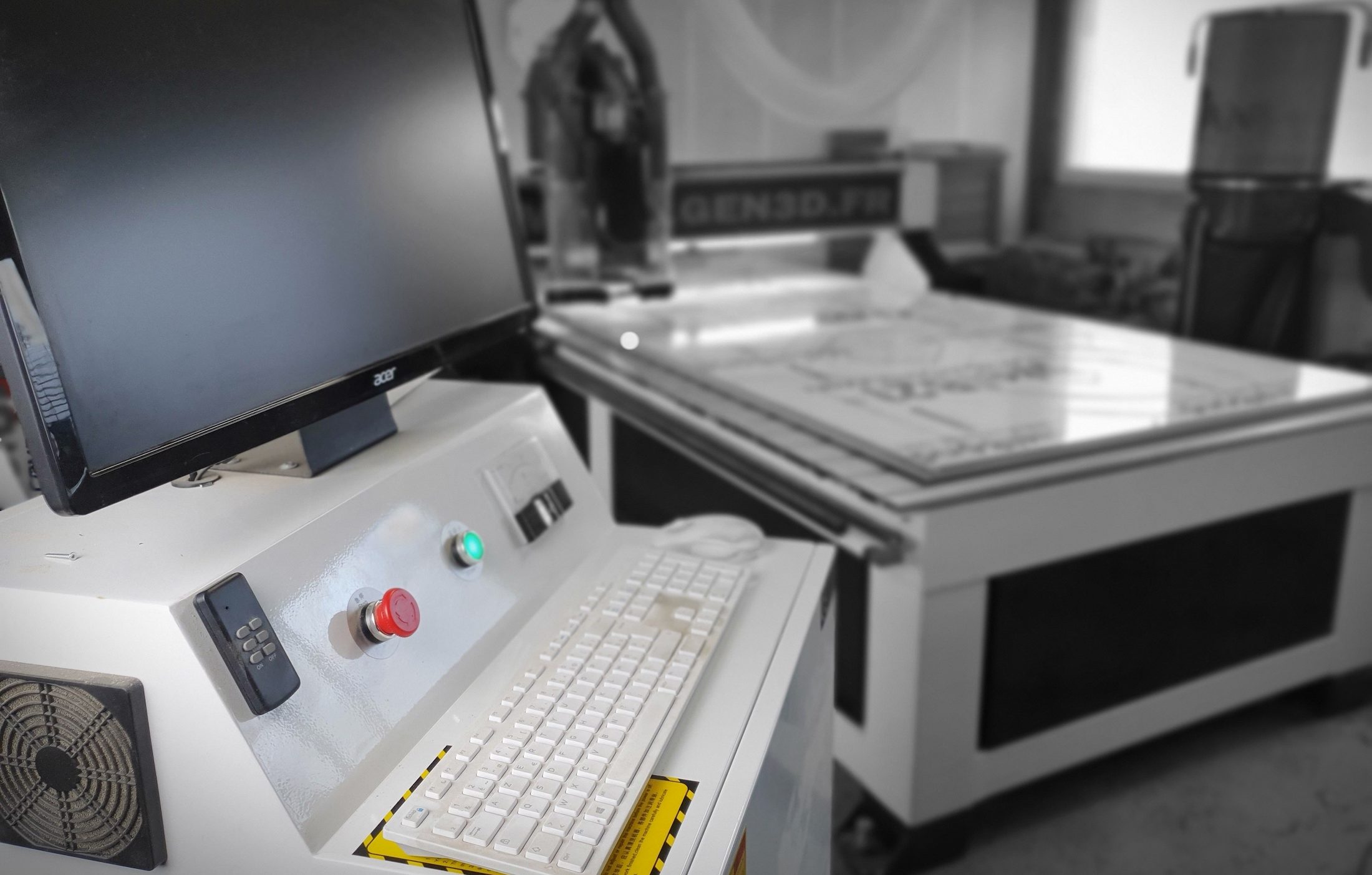 La machine à commande numérique de l’atelier Gen3D et son pupitre de commande, plateau de découpe et arrêt d’urgence au premier plan